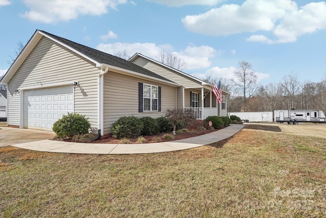 view of side of home featuring a garage, a lawn, and covered porch