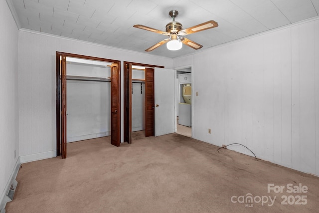 unfurnished bedroom featuring crown molding, two closets, light colored carpet, and ceiling fan