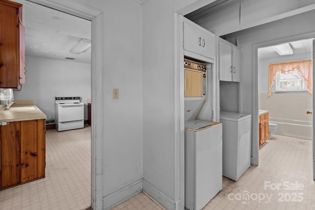 kitchen featuring sink, electric range, and washer and clothes dryer