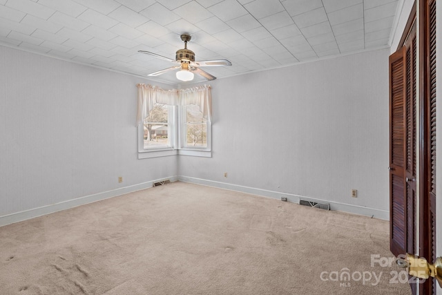 carpeted spare room featuring ceiling fan