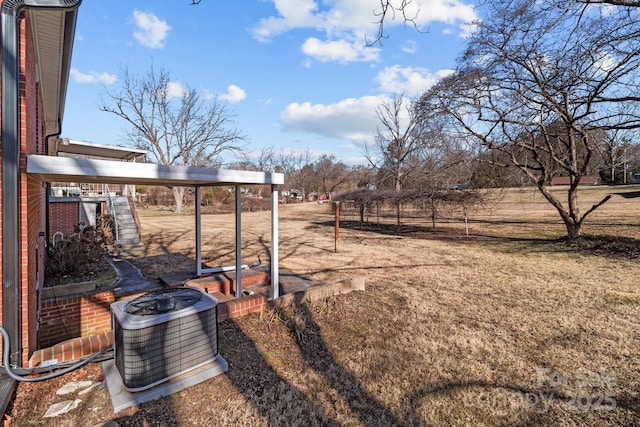 view of yard featuring a carport, a rural view, and central AC unit