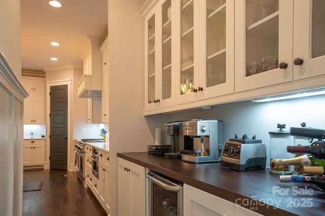 kitchen featuring tasteful backsplash, white cabinets, wine cooler, stainless steel range, and dark wood-type flooring