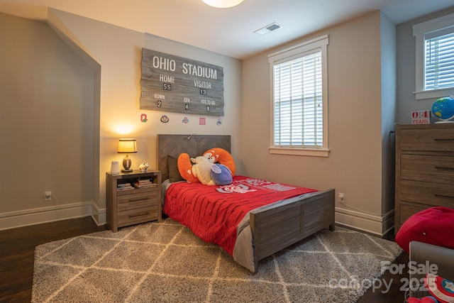 bedroom with dark wood-type flooring