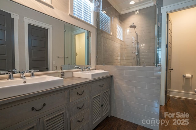 bathroom with crown molding, vanity, and hardwood / wood-style floors