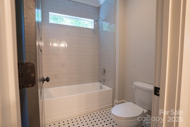 bathroom featuring tiled shower / bath and toilet