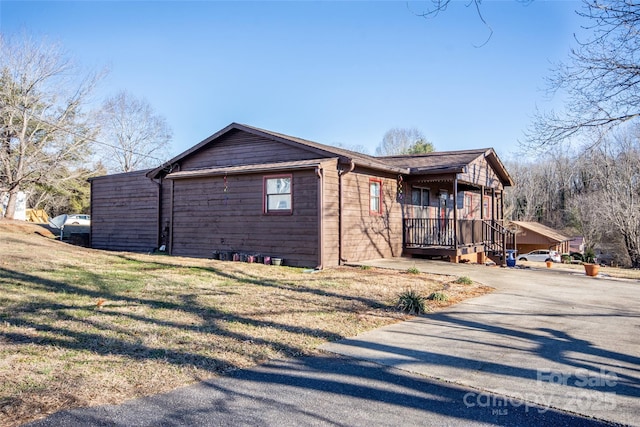 view of home's exterior featuring a lawn and covered porch