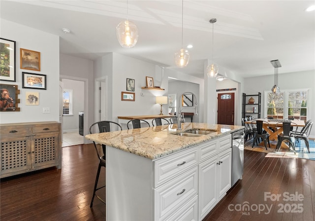 kitchen featuring sink, hanging light fixtures, dishwasher, a kitchen island with sink, and white cabinets