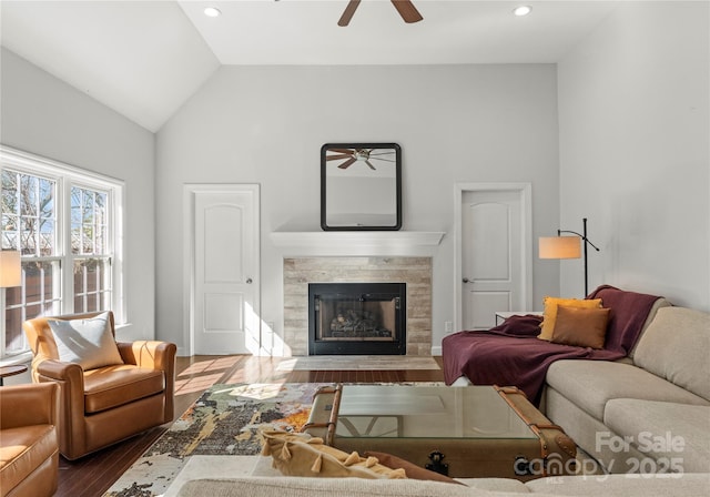 living room featuring vaulted ceiling, ceiling fan, a high end fireplace, and hardwood / wood-style floors