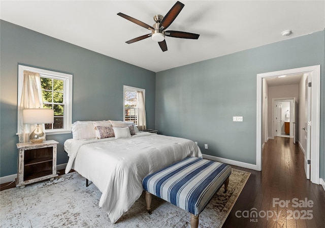 bedroom featuring multiple windows, dark hardwood / wood-style floors, and ceiling fan