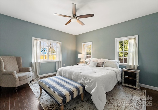 bedroom featuring multiple windows, dark hardwood / wood-style flooring, and ceiling fan