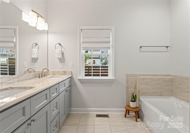 bathroom with tile patterned floors, vanity, and a tub