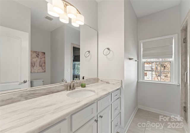 bathroom with a shower with door, an inviting chandelier, vanity, tile patterned floors, and toilet