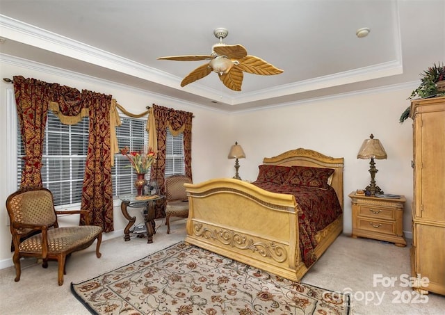 carpeted bedroom featuring a raised ceiling, crown molding, and ceiling fan