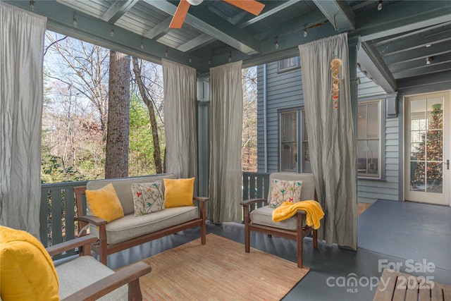 sunroom featuring beamed ceiling, plenty of natural light, and ceiling fan