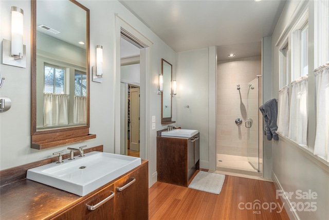 bathroom featuring vanity, hardwood / wood-style floors, and a shower with door