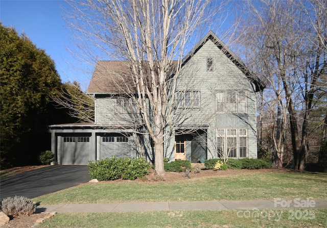 view of front facade featuring a garage, a front yard, and driveway