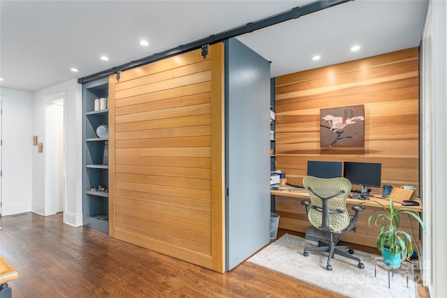 office with recessed lighting, wood finished floors, wooden walls, and a barn door