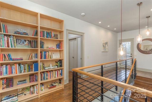 hall with dark wood-style floors, recessed lighting, baseboards, and an upstairs landing