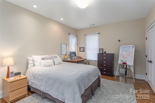 bedroom with recessed lighting, visible vents, baseboards, and wood finished floors