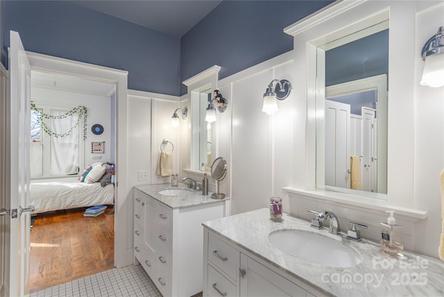 ensuite bathroom with ensuite bathroom, two vanities, a sink, and tile patterned floors