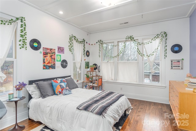 bedroom featuring visible vents, baseboards, and wood finished floors