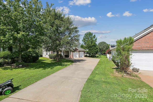 view of property hidden behind natural elements featuring a garage and a front lawn