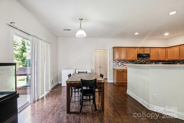 kitchen featuring dark hardwood / wood-style floors, decorative light fixtures, and decorative backsplash