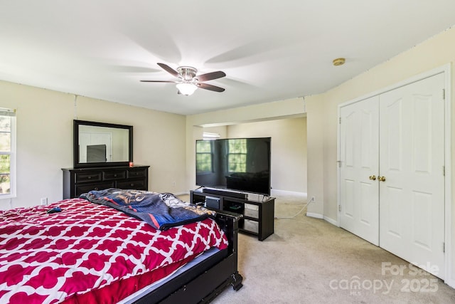 carpeted bedroom with ceiling fan and a closet