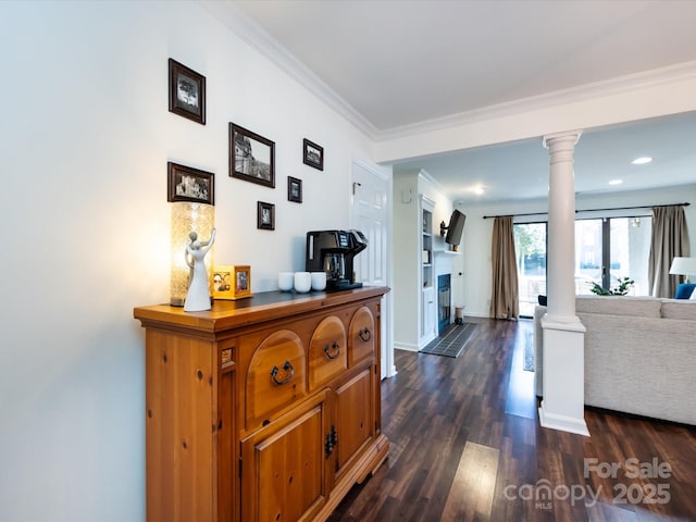 hall featuring dark hardwood / wood-style flooring, ornamental molding, and ornate columns