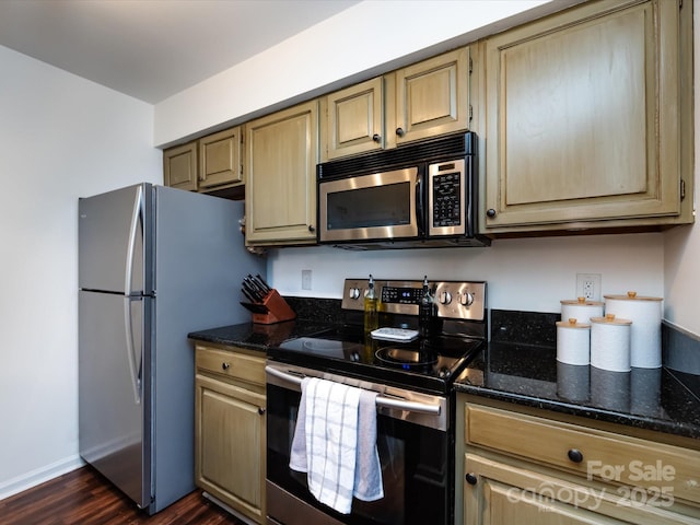 kitchen with stainless steel appliances, dark hardwood / wood-style floors, light brown cabinets, and dark stone counters