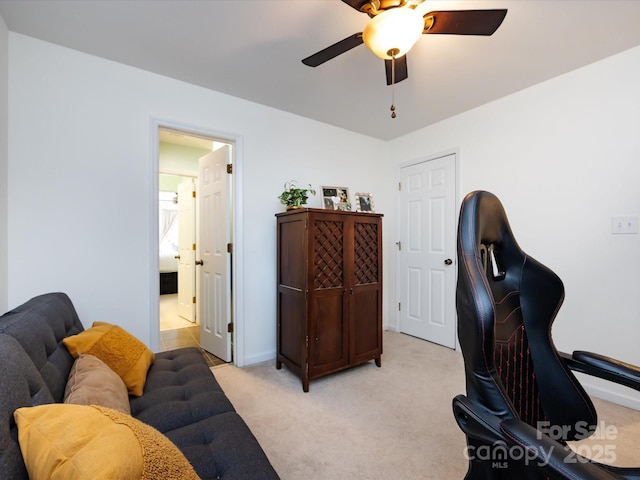 carpeted office space with ceiling fan