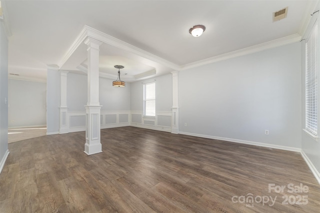 interior space with ornamental molding, dark hardwood / wood-style floors, a raised ceiling, and ornate columns