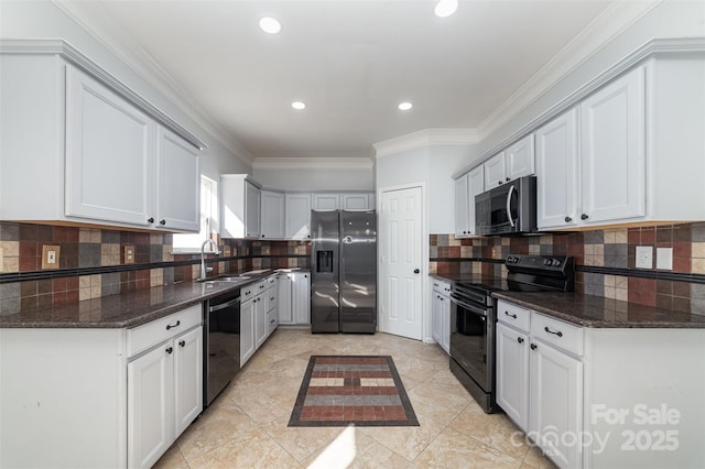 kitchen featuring white cabinetry, ornamental molding, dark stone counters, and black appliances