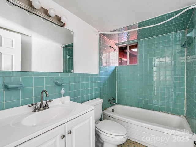 full bathroom with tile walls, vanity, tiled shower / bath combo, and toilet