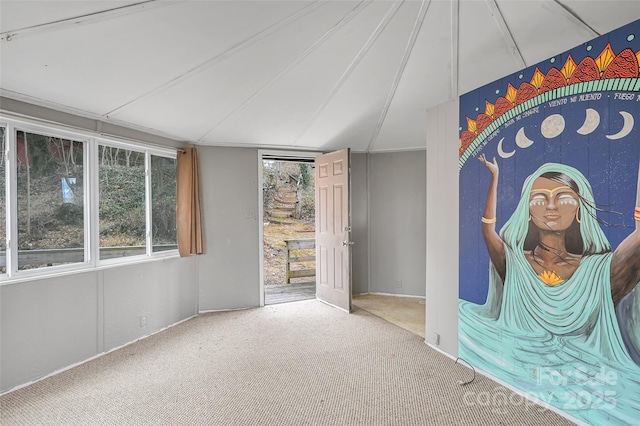 carpeted spare room with plenty of natural light and vaulted ceiling