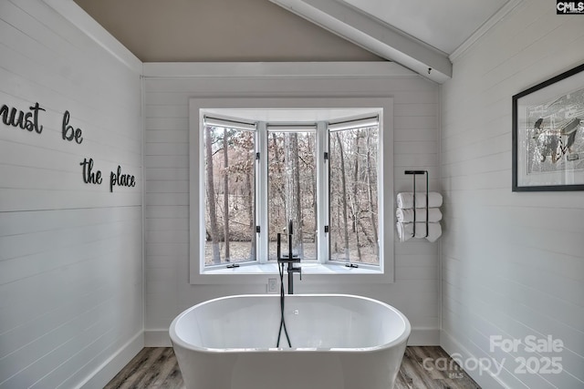 bathroom with hardwood / wood-style floors and a tub to relax in