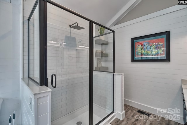 bathroom featuring vaulted ceiling, wood-type flooring, and walk in shower