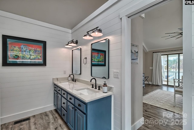 bathroom with crown molding, vanity, and hardwood / wood-style floors