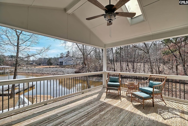 wooden deck with a water view and ceiling fan