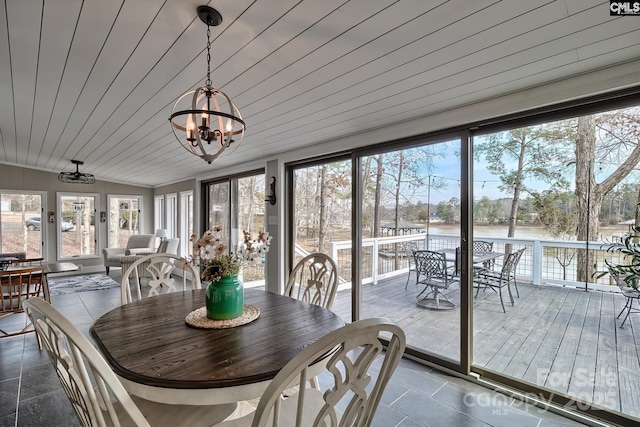 sunroom with a water view, wooden ceiling, and an inviting chandelier