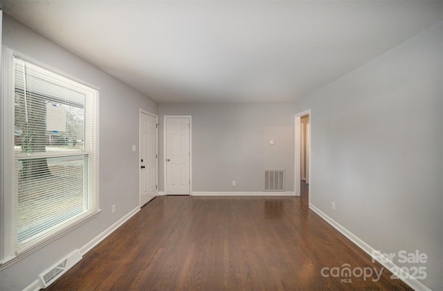 empty room with dark wood-type flooring