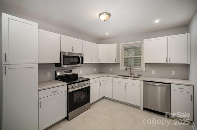 kitchen featuring stainless steel appliances, sink, and white cabinets