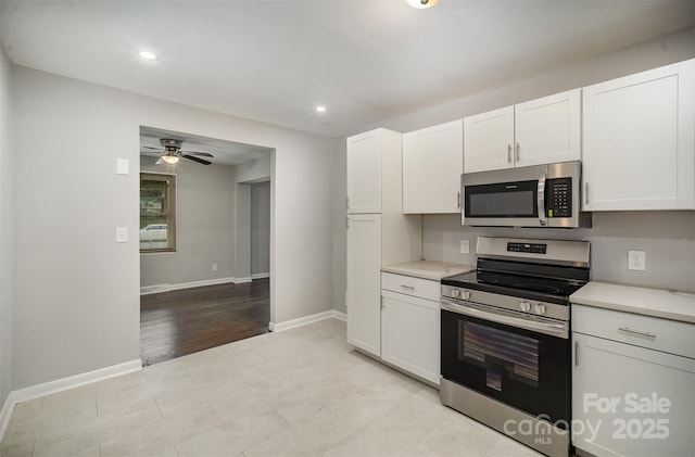 kitchen with stainless steel appliances, white cabinets, and ceiling fan