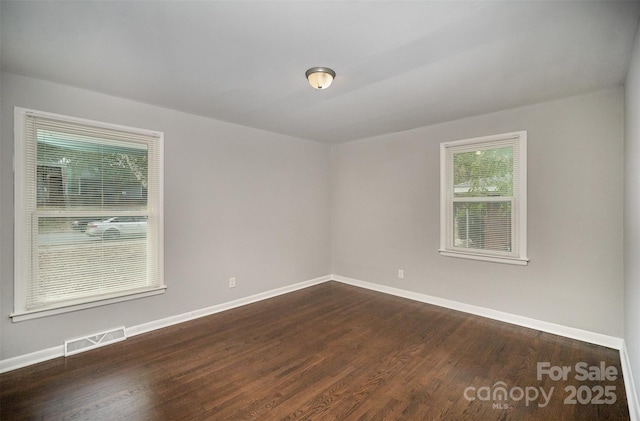 empty room with dark hardwood / wood-style flooring