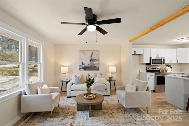 living room with ceiling fan and light hardwood / wood-style floors