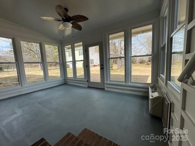 unfurnished sunroom with ceiling fan and vaulted ceiling