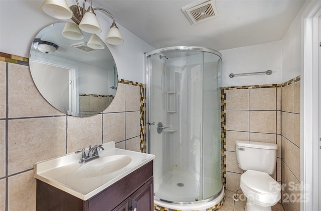 bathroom featuring vanity, tile walls, an enclosed shower, and toilet