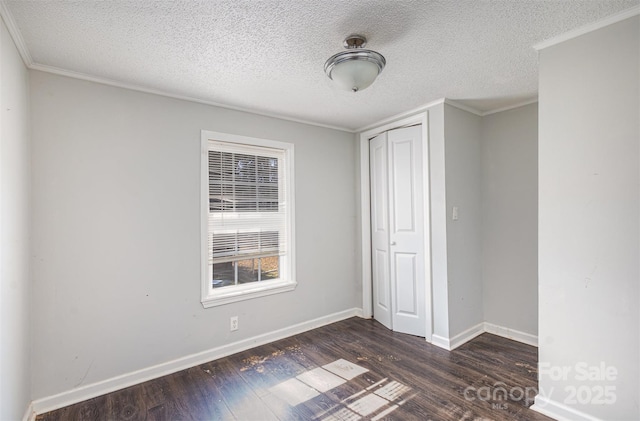 unfurnished bedroom with a closet, ornamental molding, dark hardwood / wood-style floors, and a textured ceiling