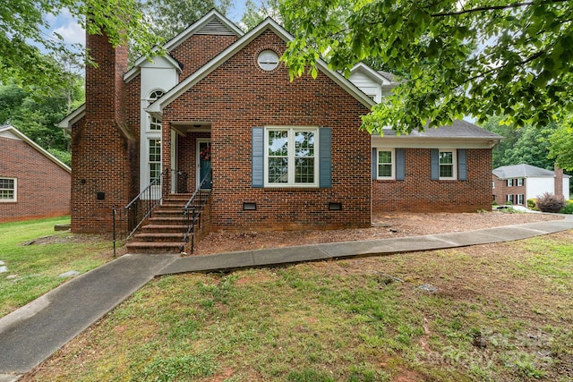 traditional-style home featuring a front lawn, a chimney, and brick siding