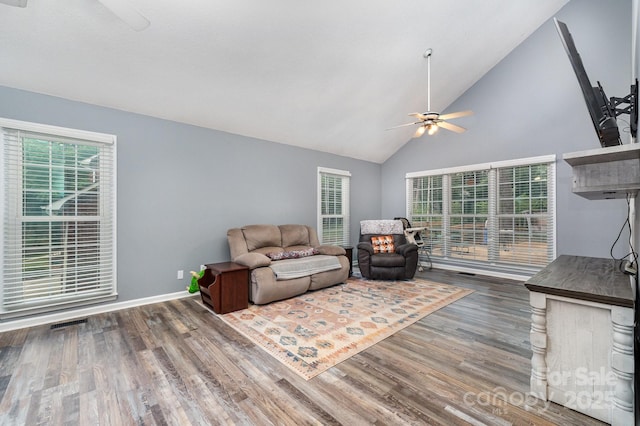 living room featuring ceiling fan, wood finished floors, high vaulted ceiling, and baseboards